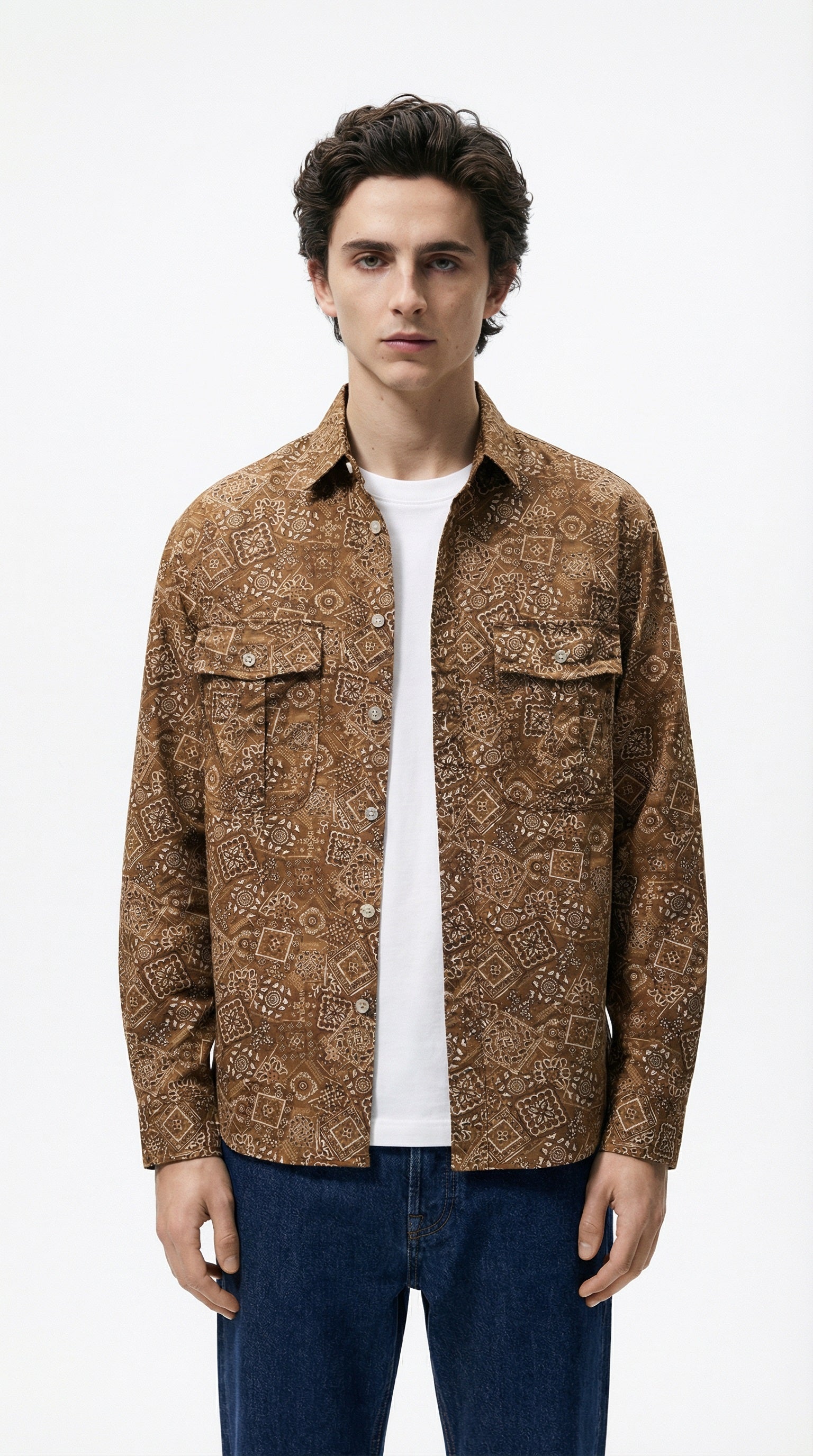 Person wearing a patterned brown jacket against a dark background