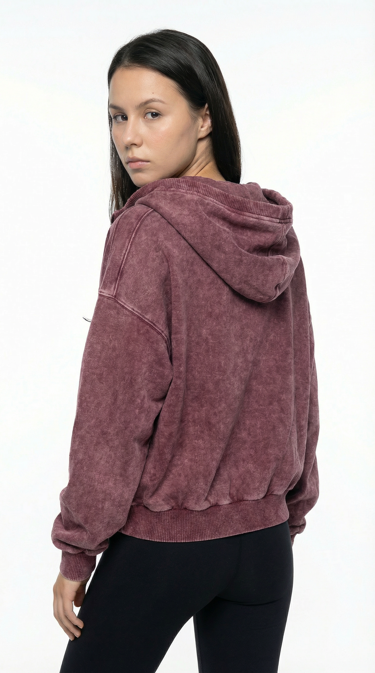 Woman wearing a maroon hoodie on a white background