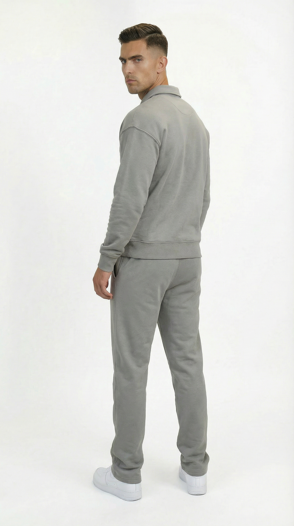 Man wearing a gray tracksuit on a white background