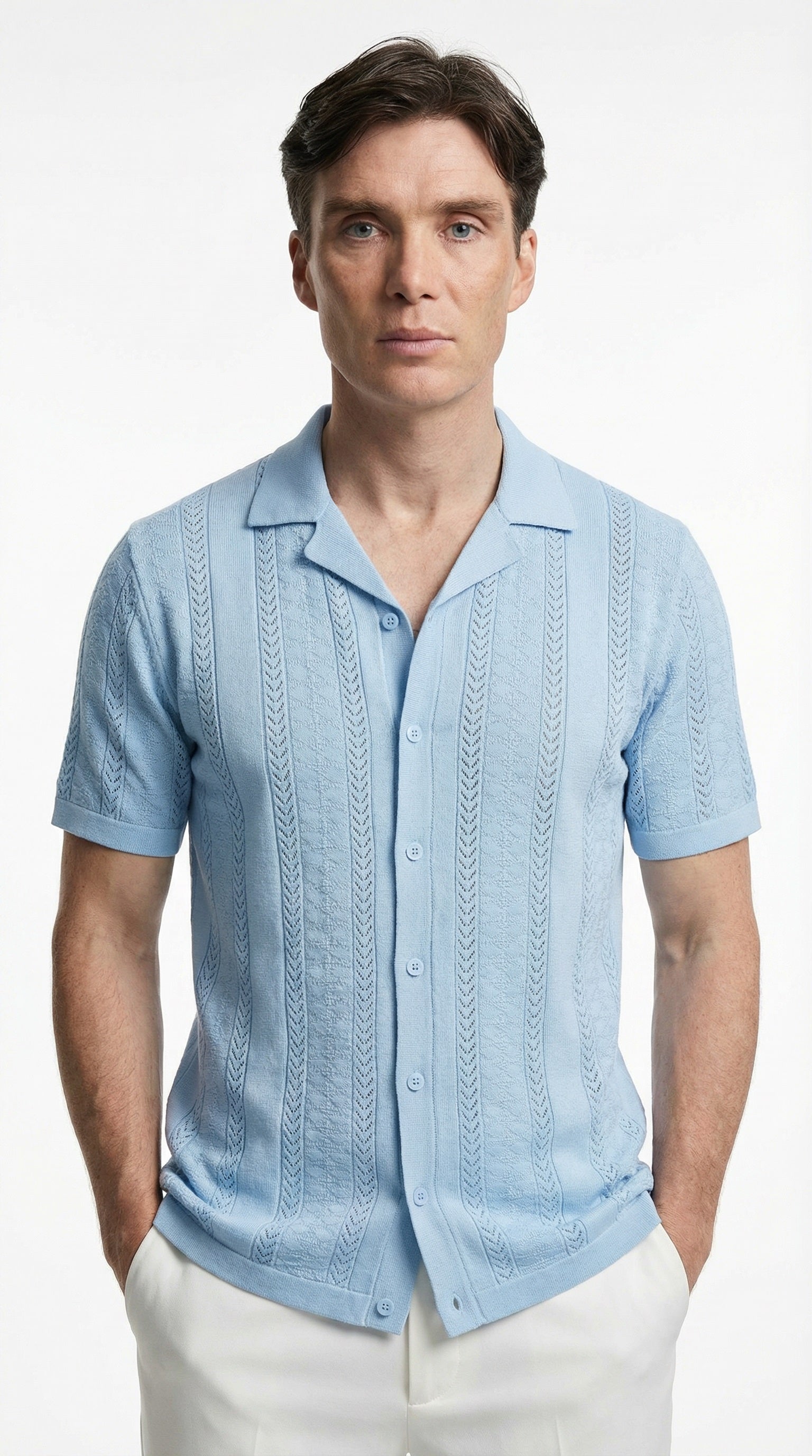 Man wearing a light blue patterned shirt in an indoor setting