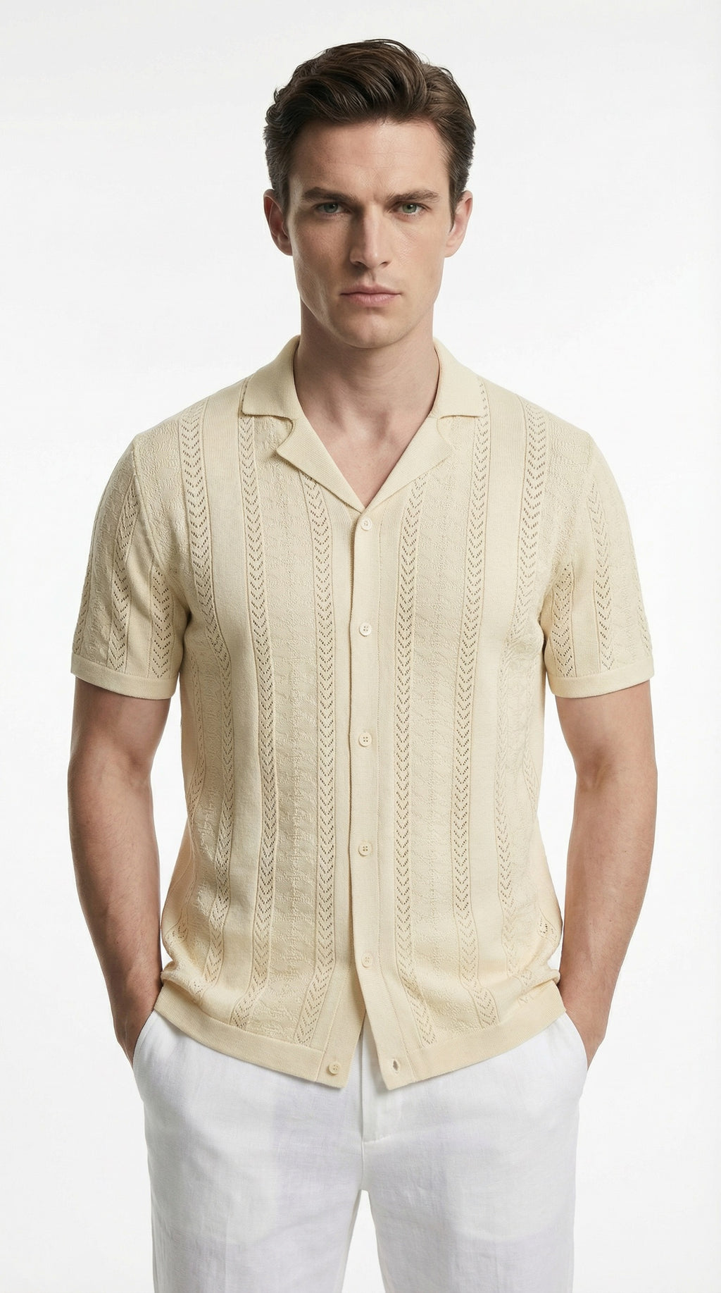 Man wearing a beige short-sleeve button-up shirt and white pants on a white background