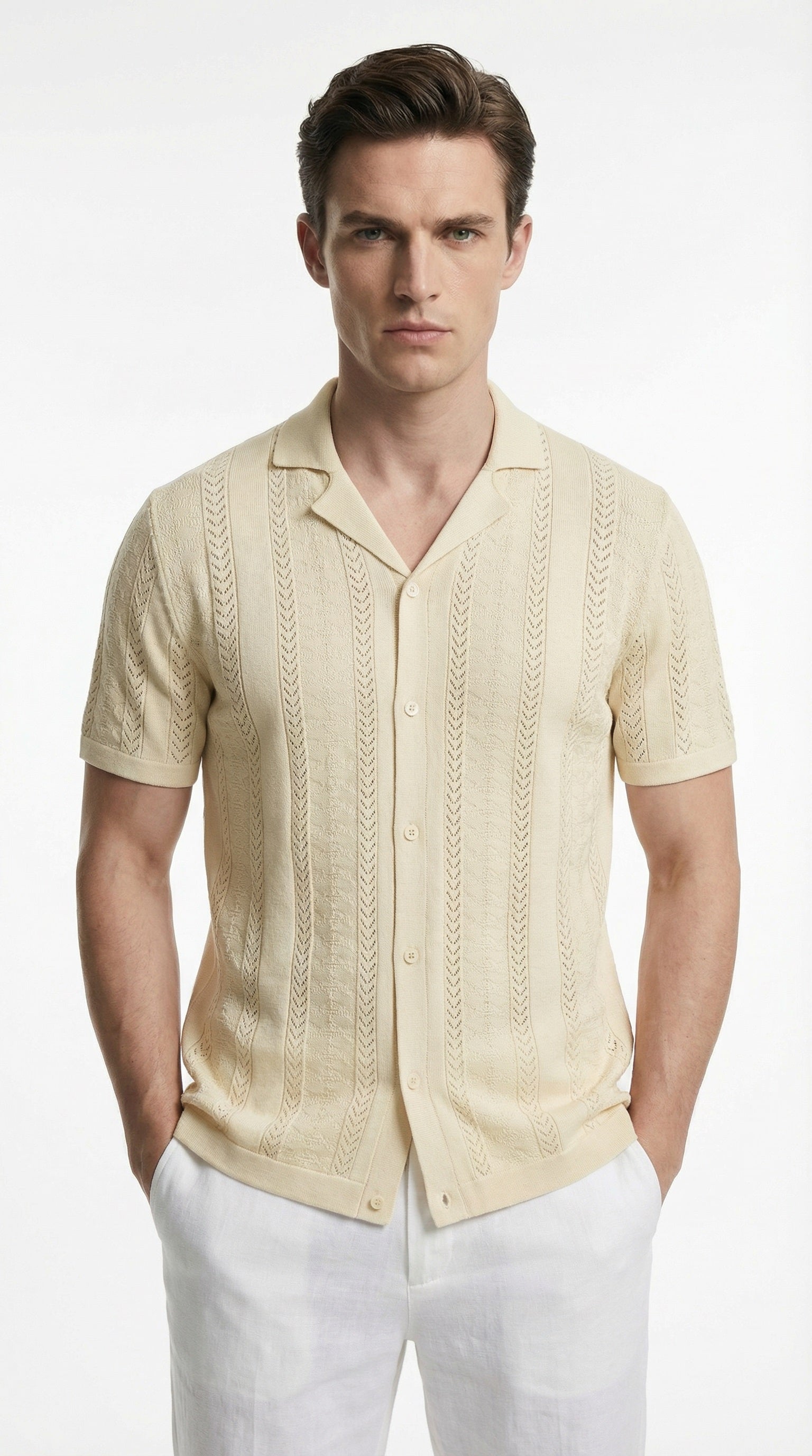 Man wearing a beige short-sleeve button-up shirt and white pants on a white background