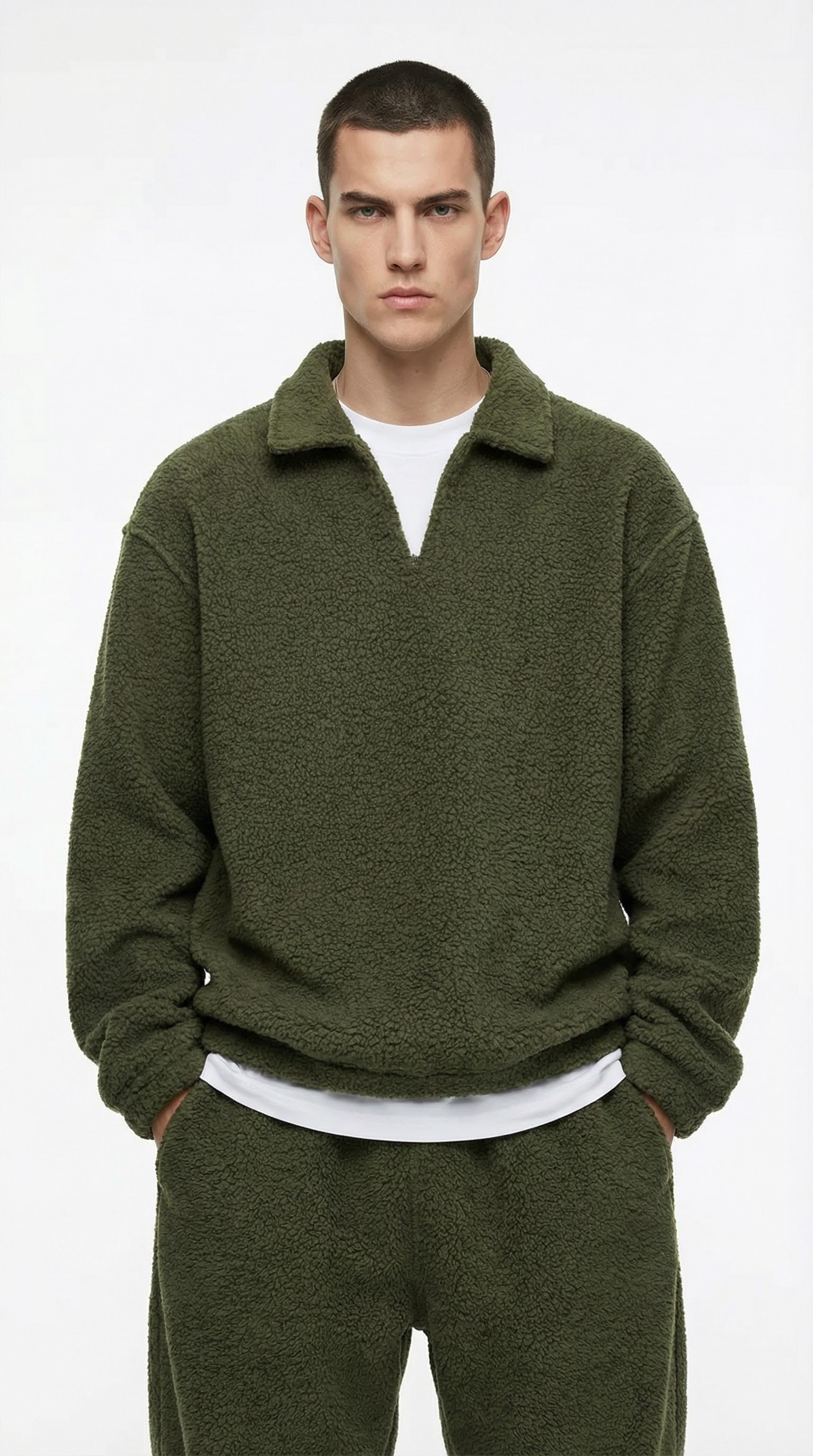 Man wearing a green sweater and pants on a white background