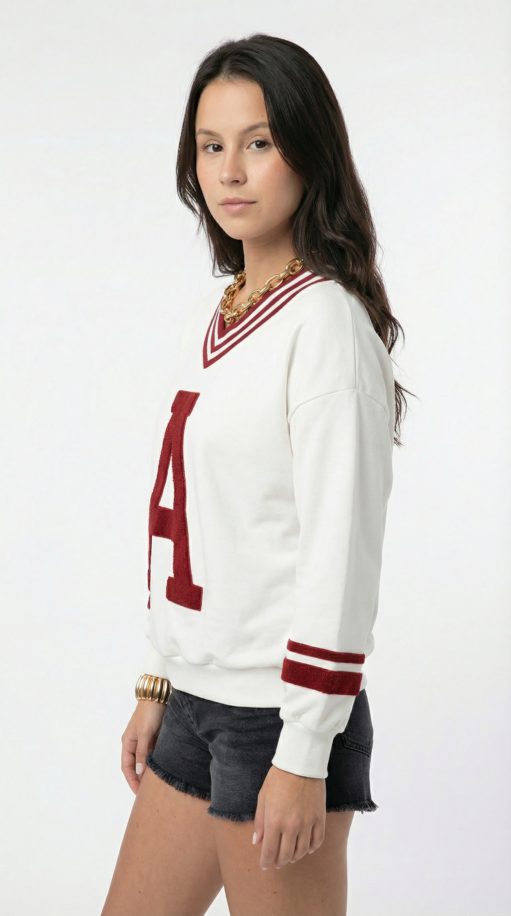 Woman wearing a white sweater with red accents on a white background
