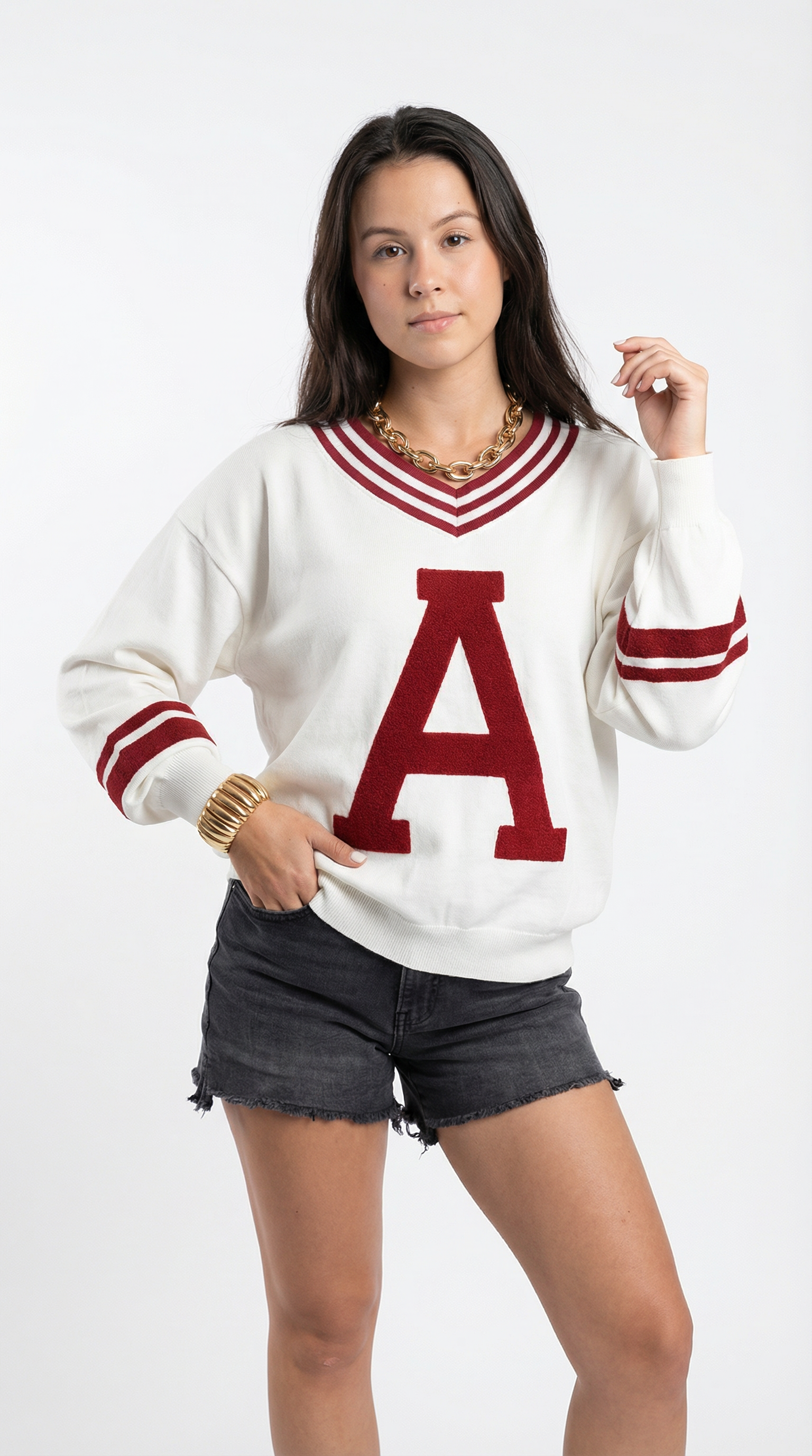 Person wearing a white sweater with a red 'A' and black shorts on a white background
