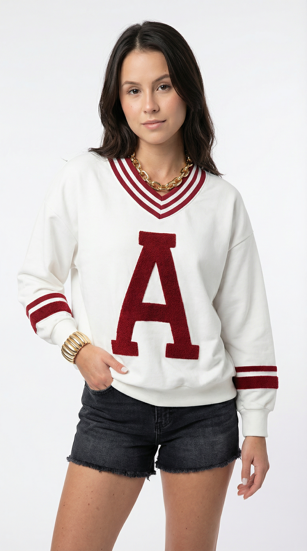 Woman wearing a white sweater with a red 'A' and black shorts on a white background