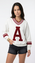Woman wearing a white sweater with a red 'A' and black shorts on a white background