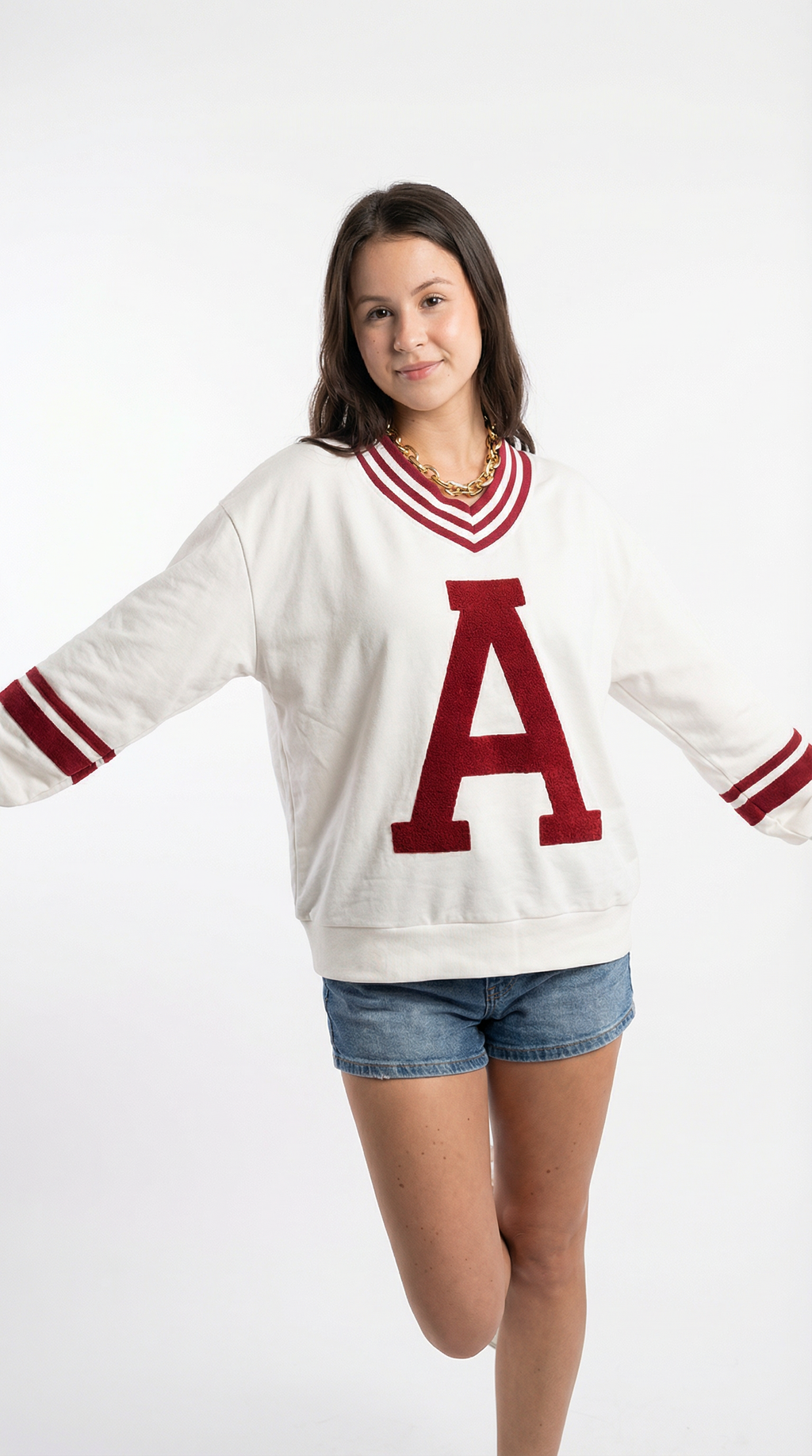 Person wearing a white sweater with a red 'A' on a white background
