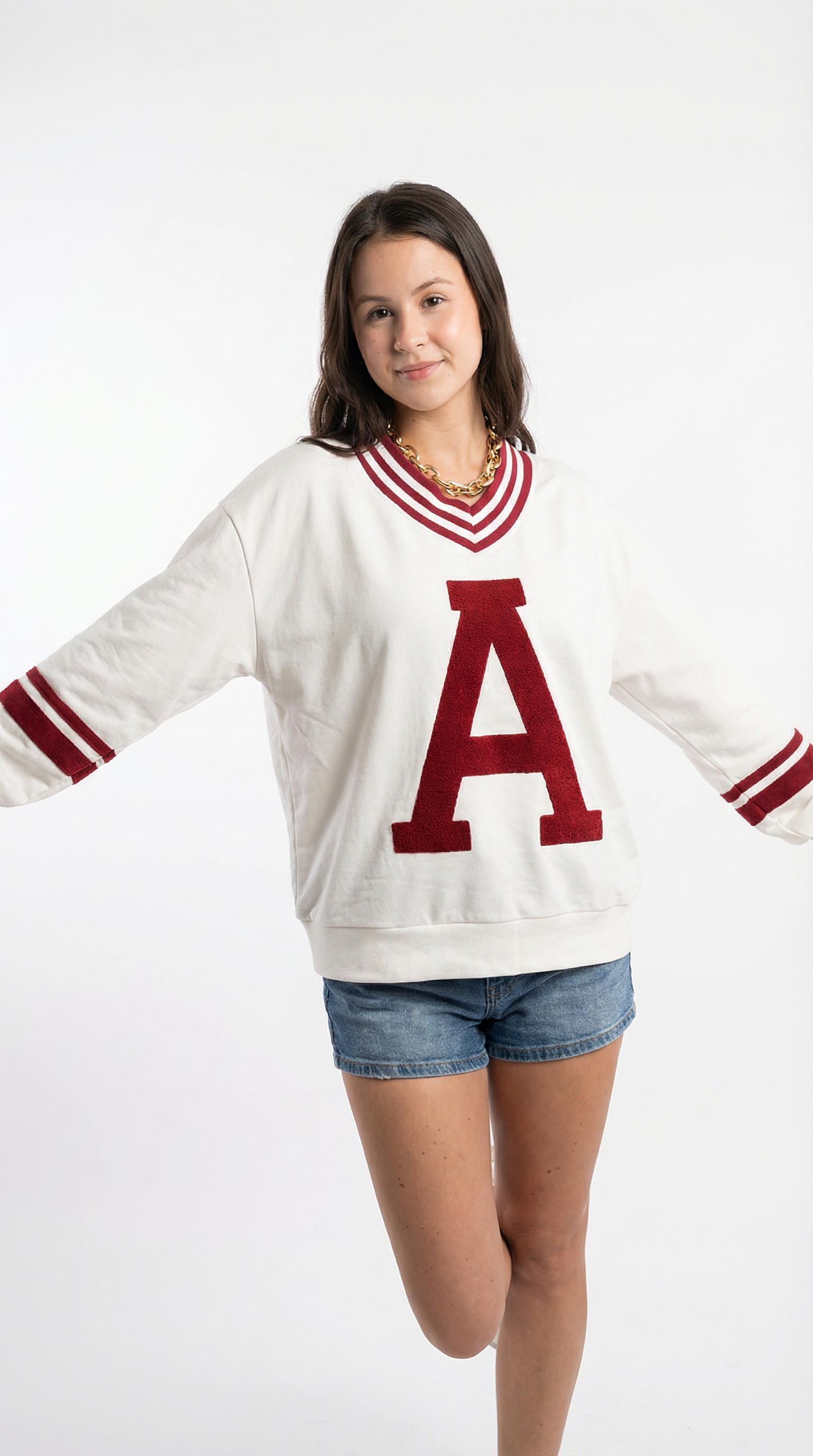 Person wearing a white sweater with a red 'A' on a white background