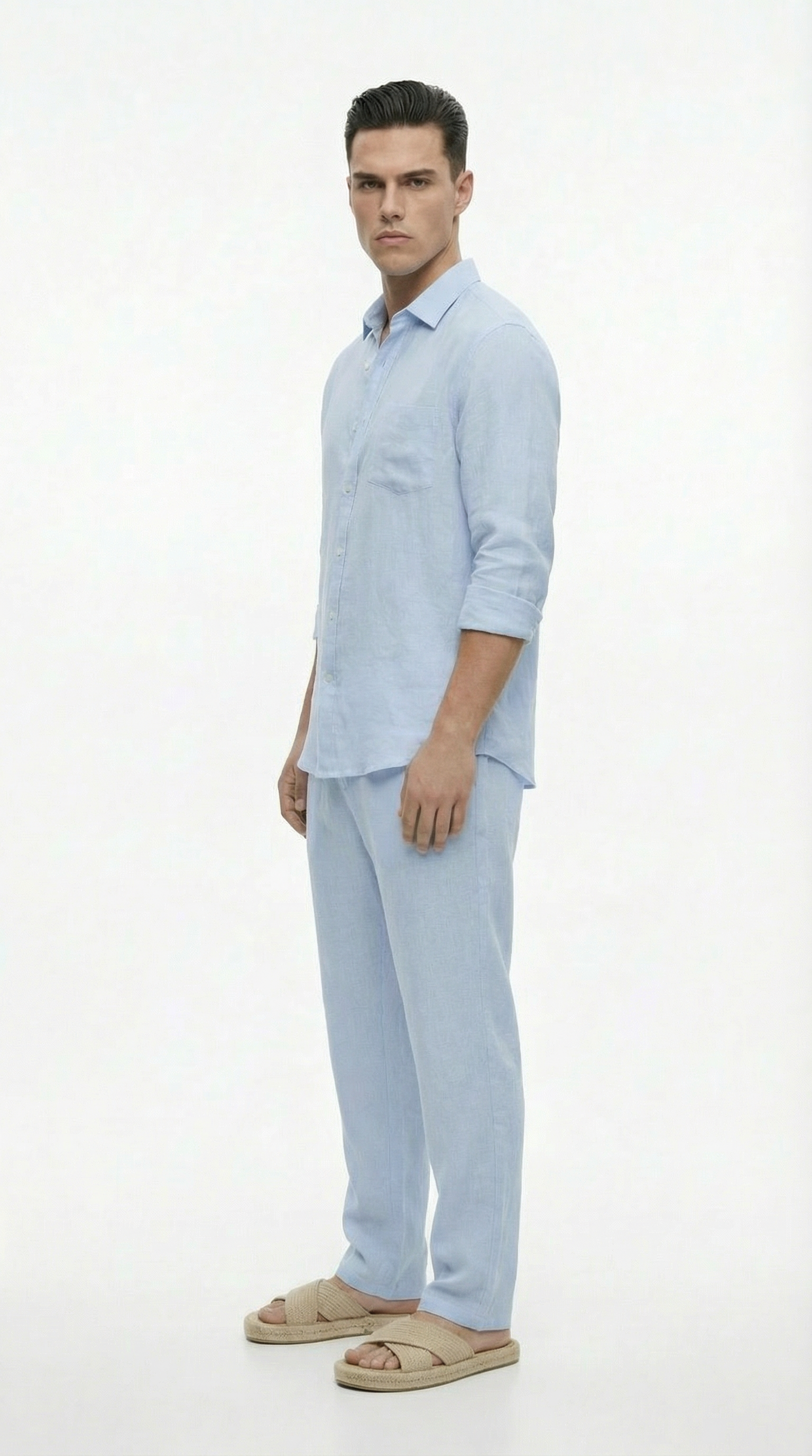 Man wearing a light blue shirt and pants on a white background