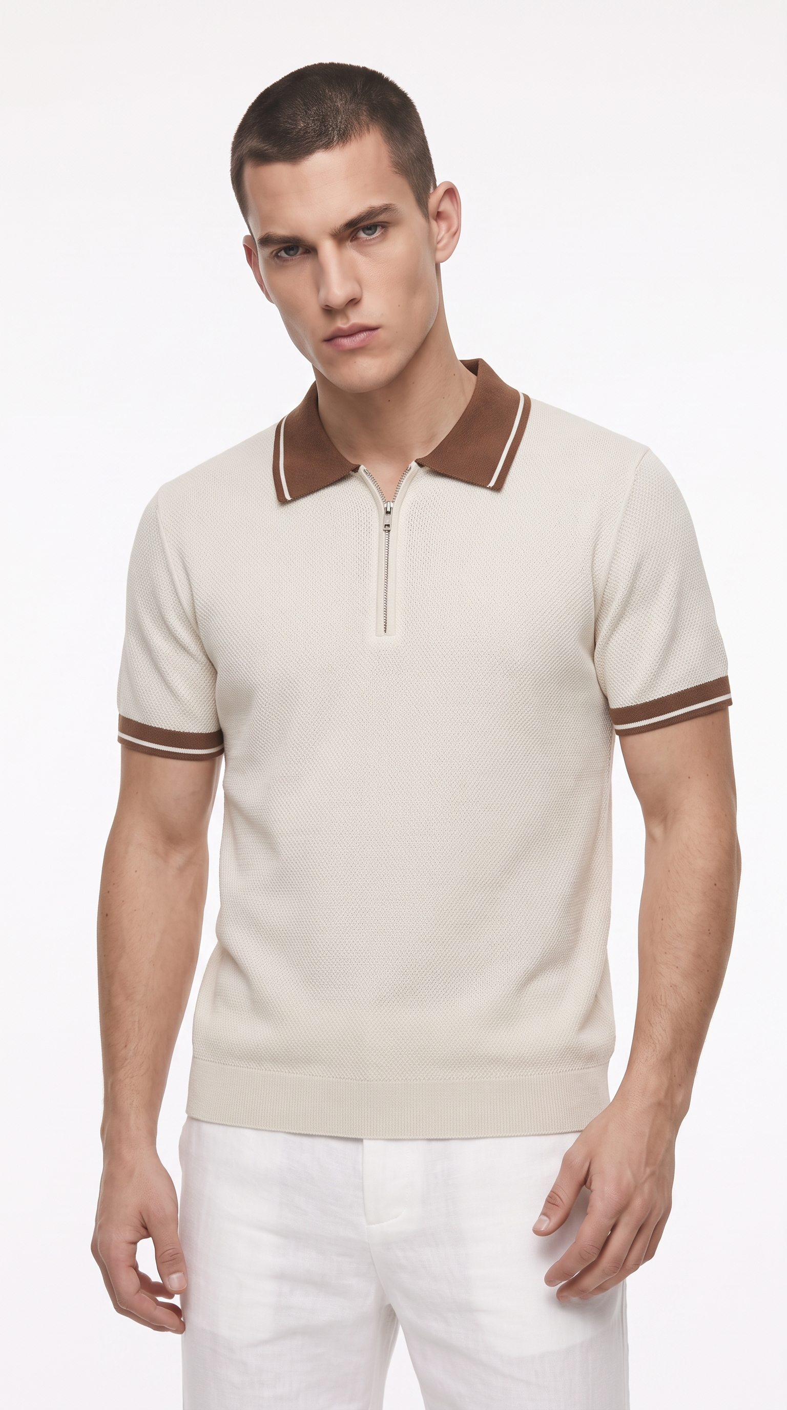 A male model wearing a short-sleeve knit polo shirt in cream with brown collar and sleeve trim, paired with white trousers, against a plain white studio background, from Meleche Fashion USA or Meléche (short as (Mé))