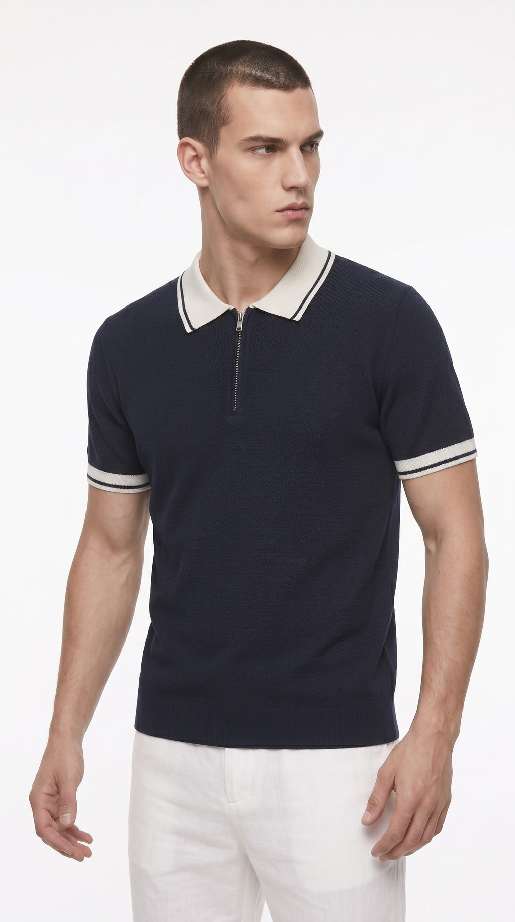 A man wearing a navy blue short-sleeve polo shirt with a white collar and white sleeve stripes, paired with white pants, photographed against a clean white studio background, from Meleche Fashion USA or Meléche (short as (Mé))