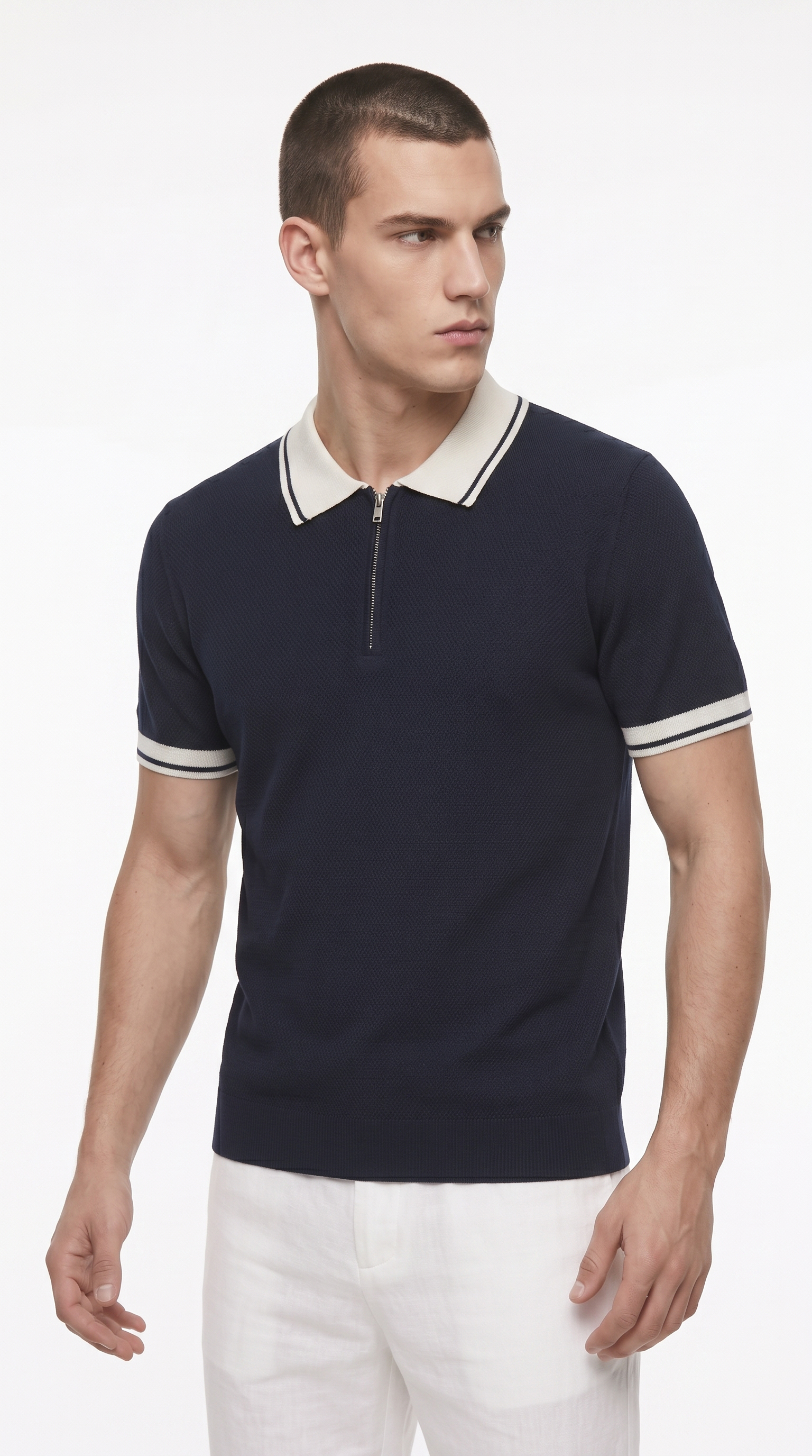 A man wearing a navy blue short-sleeve polo shirt with a white collar and white sleeve stripes, paired with white pants, photographed against a clean white studio background, from Meleche Fashion USA or Meléche (short as (Mé))
