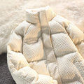 White quilted jacket on a textured from Meleche or Meléche (short as (Mé)) white surface