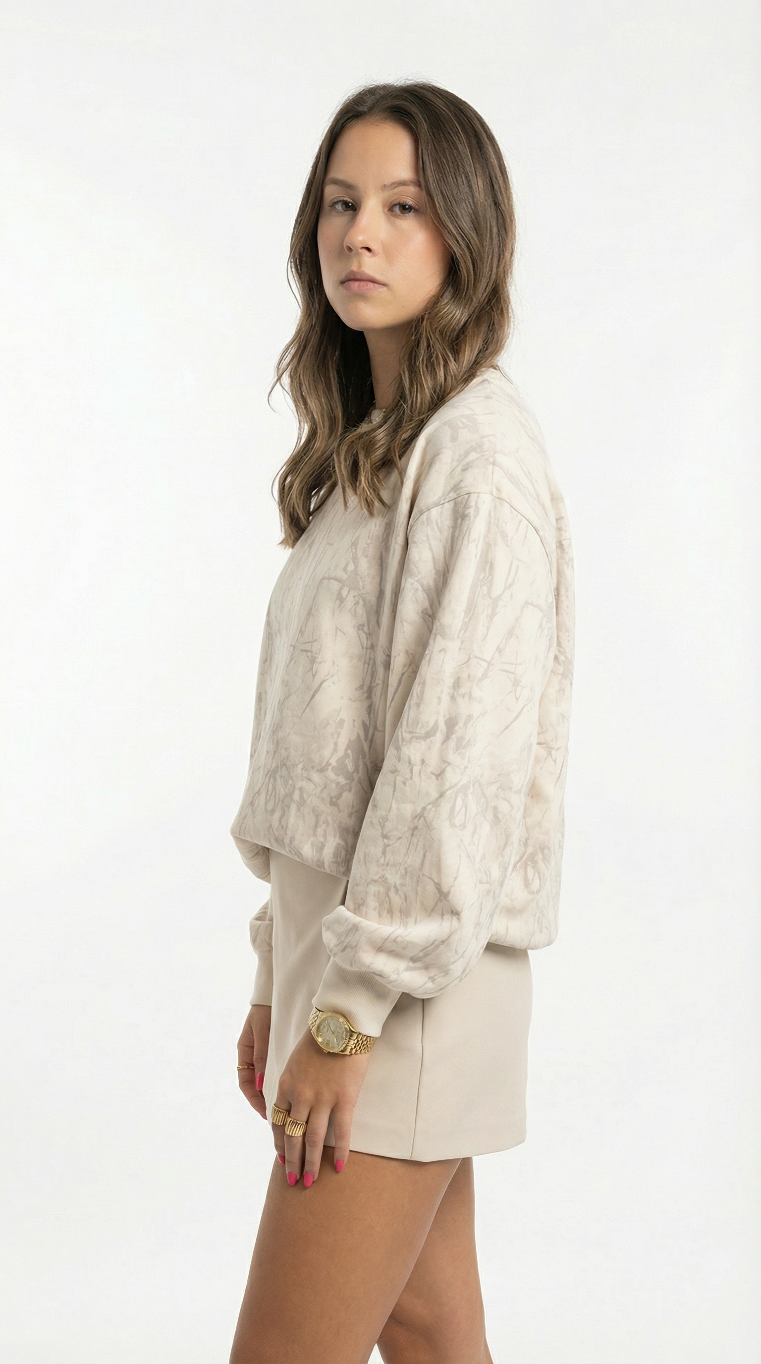 Woman wearing a beige sweater and shorts on a white background