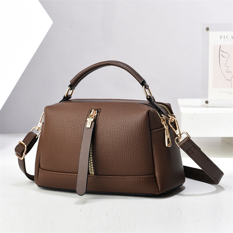 Oleg bag - Brown handbag with gold zippers on a white background