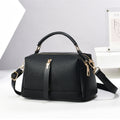 Oleg bag - Black handbag with gold accents on a white background