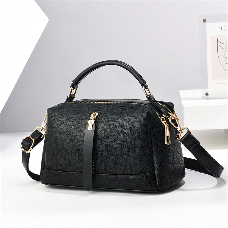 Oleg bag - Black handbag with gold accents on a white background