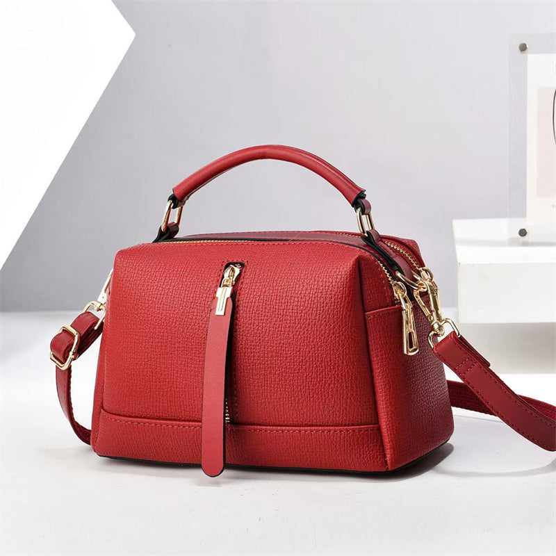 Oleg bag - Red handbag with gold accents on a light gray background