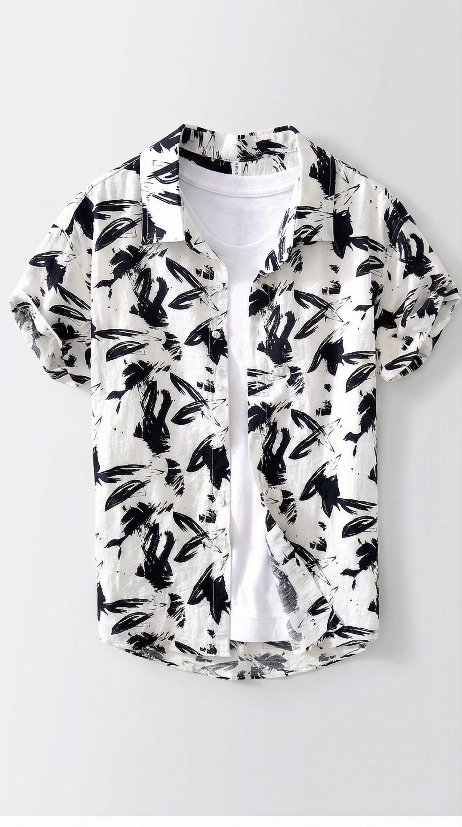 White shirt with black leaf pattern on a white background