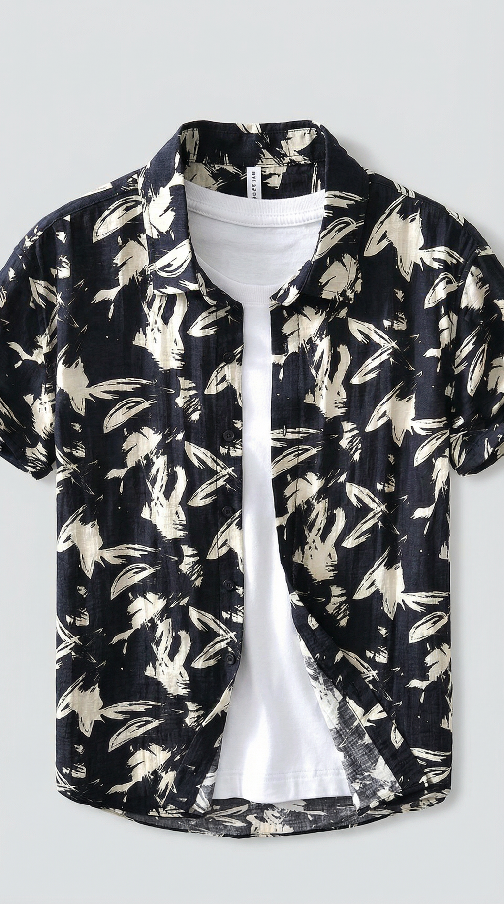 Black floral patterned shirt over a white t-shirt on a light gray background