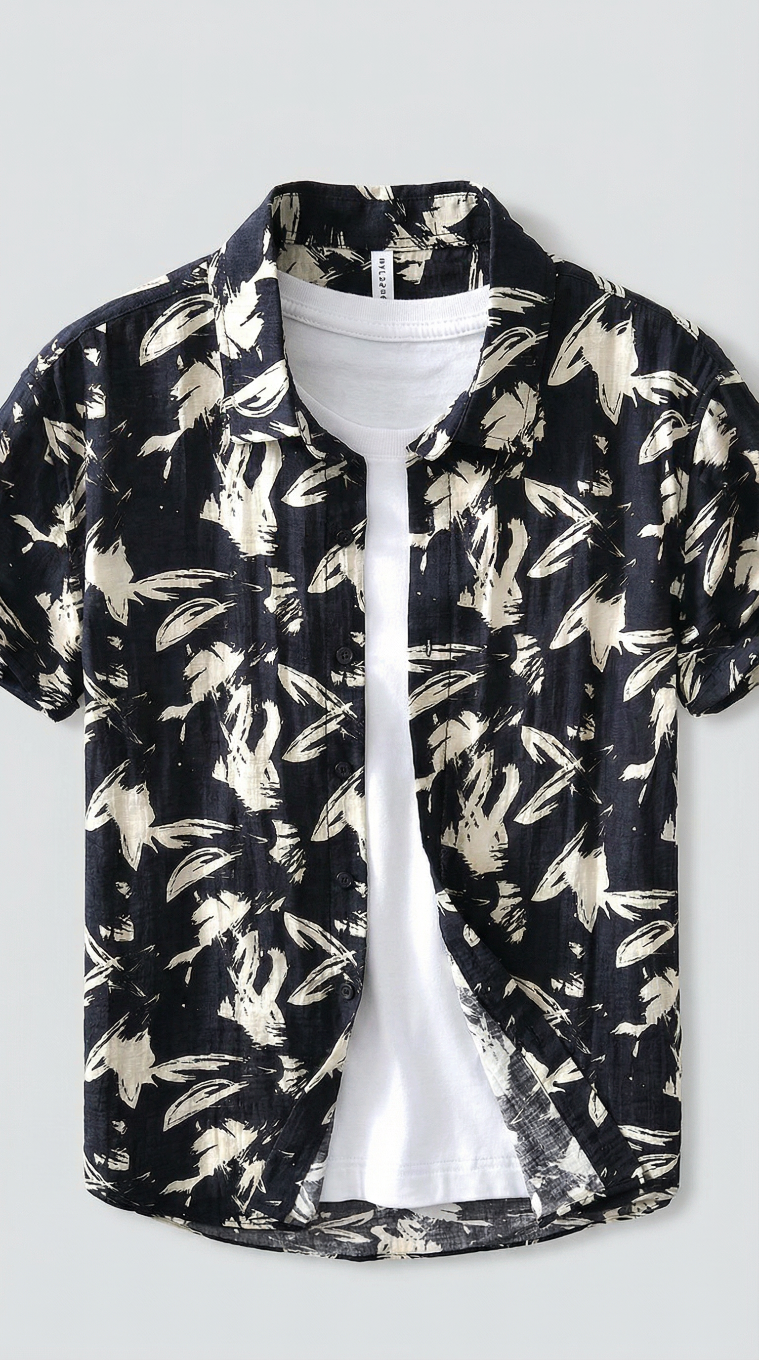 Black floral patterned shirt over a white t-shirt on a light gray background