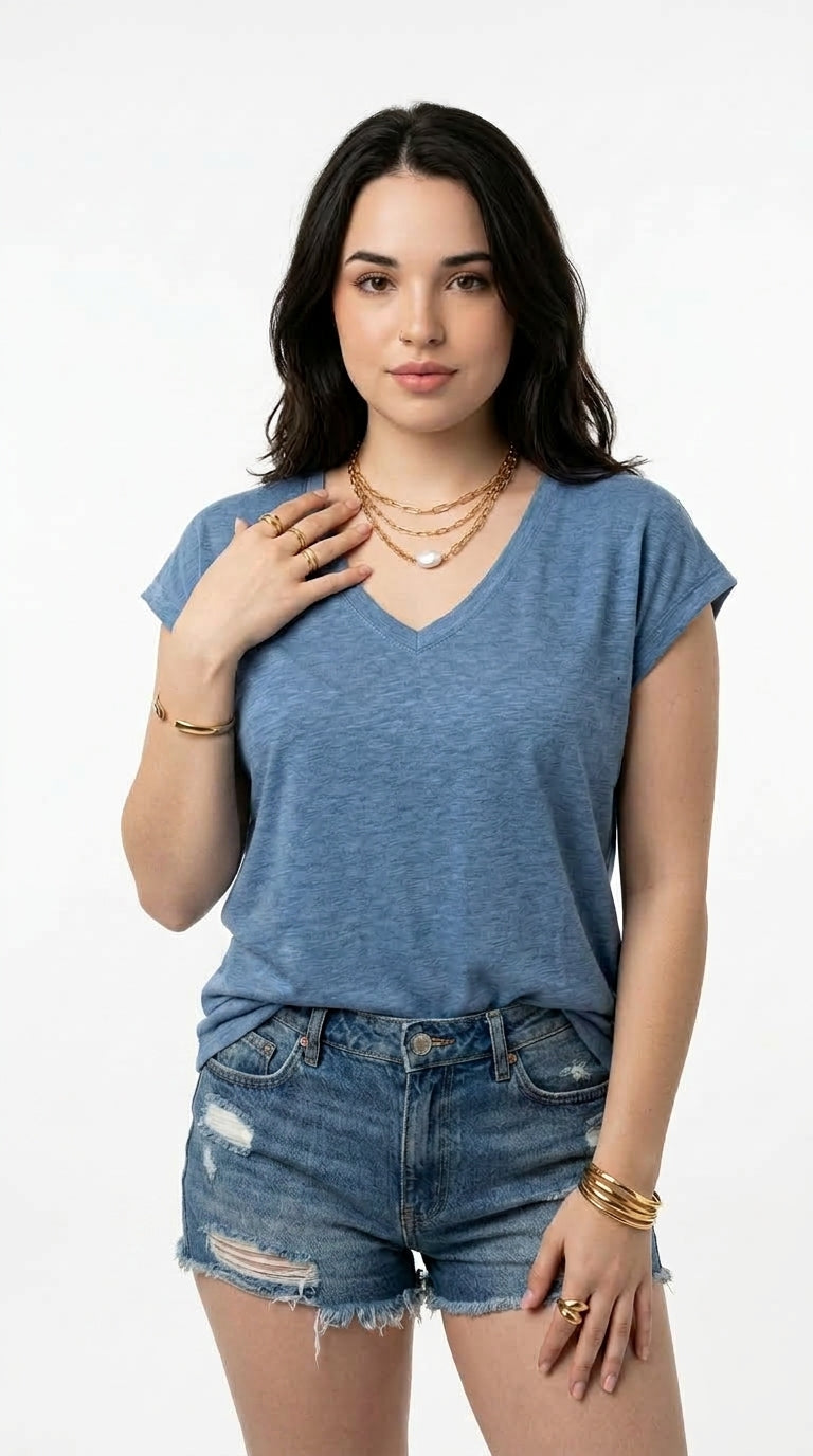 A woman modeling a heathered slate blue v-neck t-shirt with short sleeves, paired with distressed denim shorts, against a plain white studio background, from Meleche Fashion USA or Meléche (short as (Mé))
