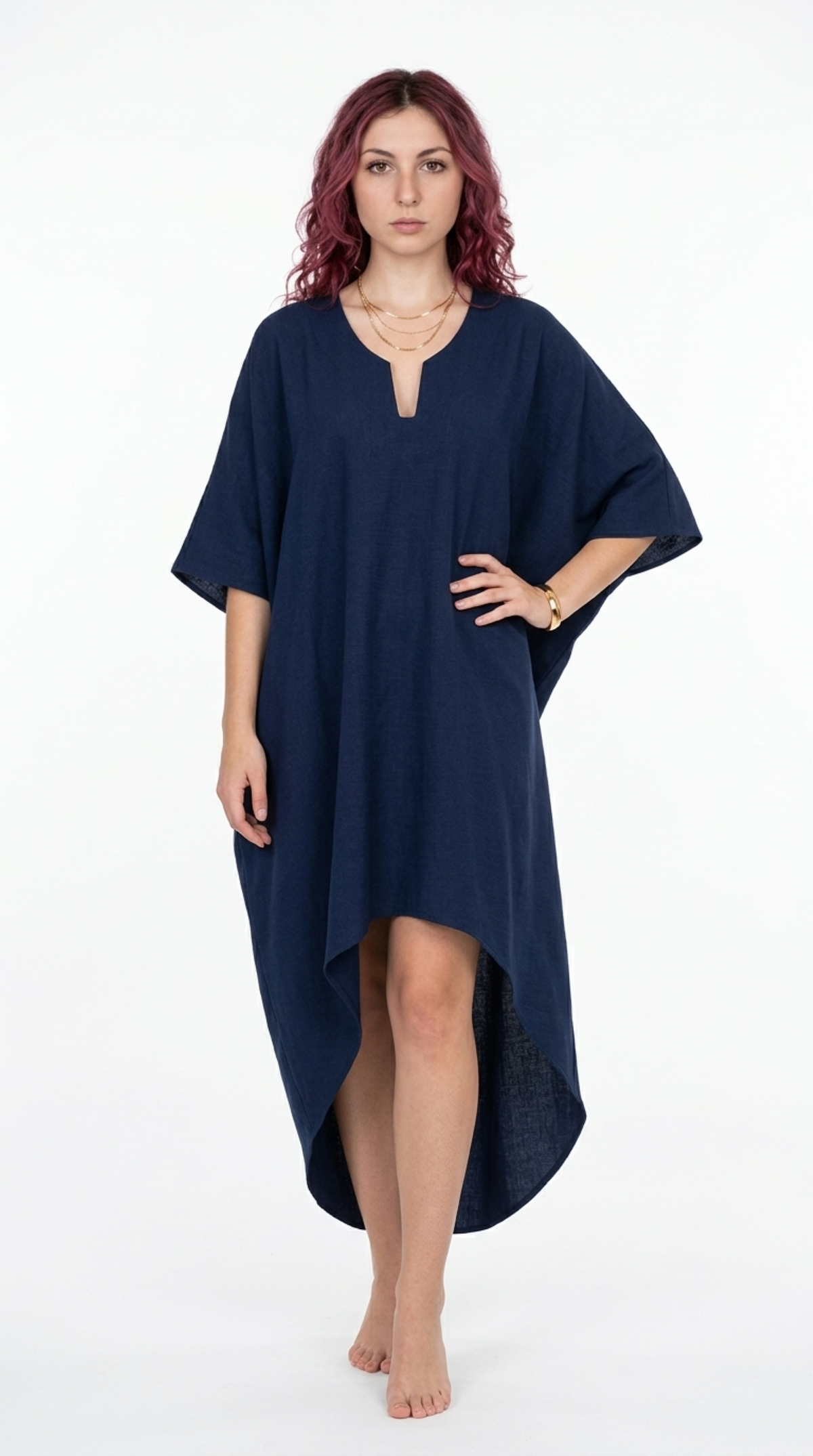 A woman modeling a loose, high-low navy blue kaftan dress against a plain white studio background, from Meleche Fashion or Meléche (short as (Mé)) and shoot taken by Meléche studio photography NYC-USA