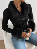 Person wearing a black ribbed sweater with fur trim holding a coffee cup.