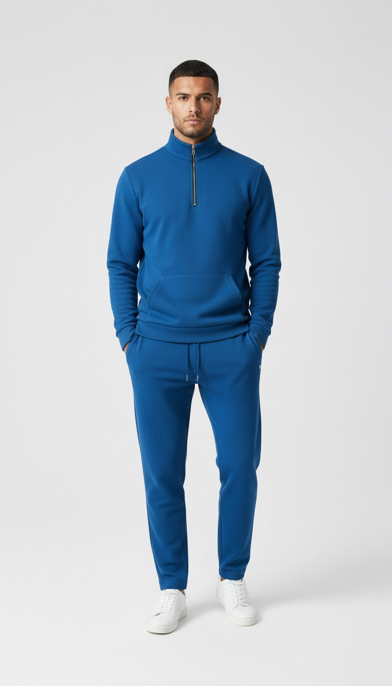 Man in a blue tracksuit walking on a city street