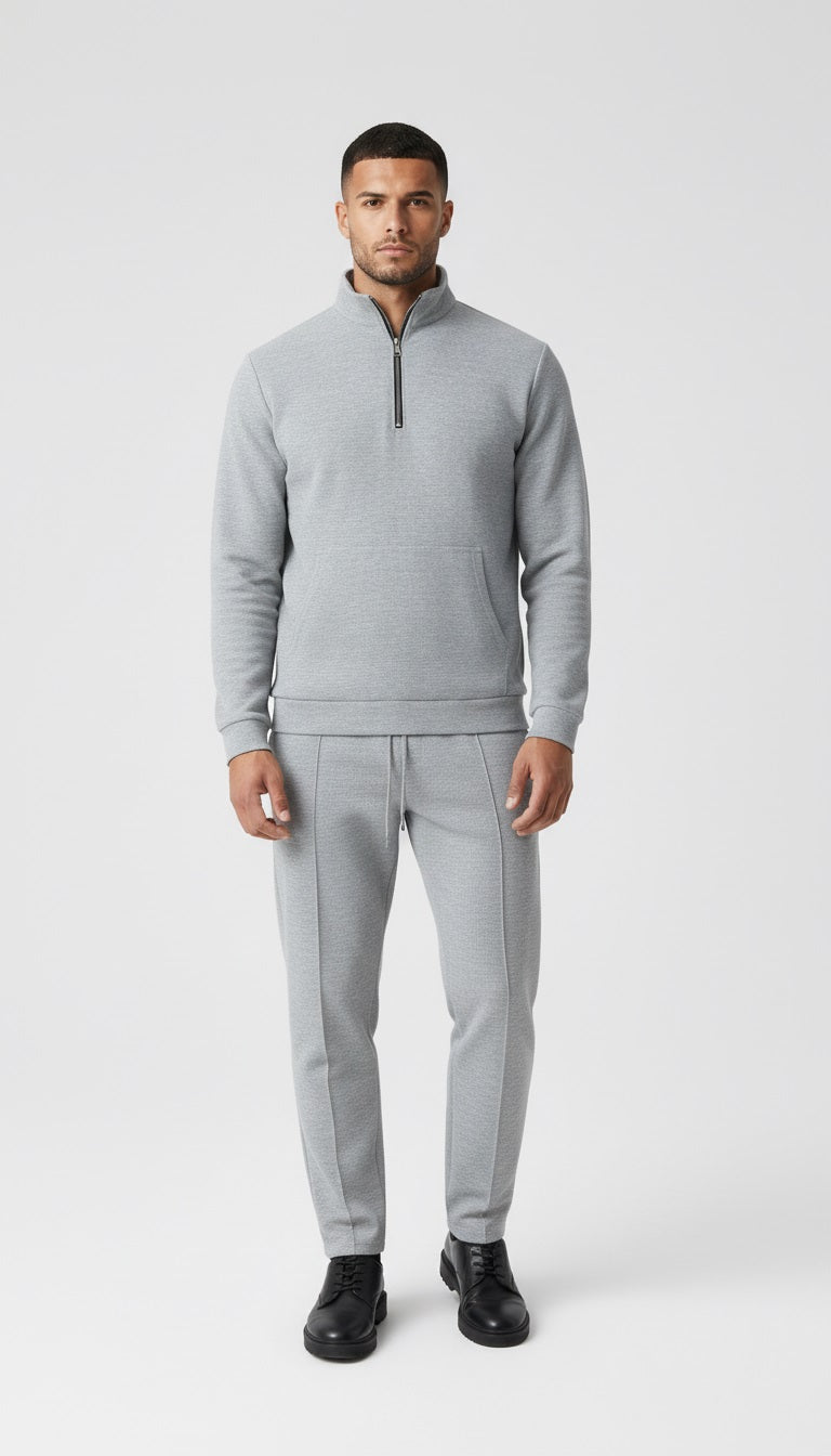 Man in a gray outfit walking on a city street