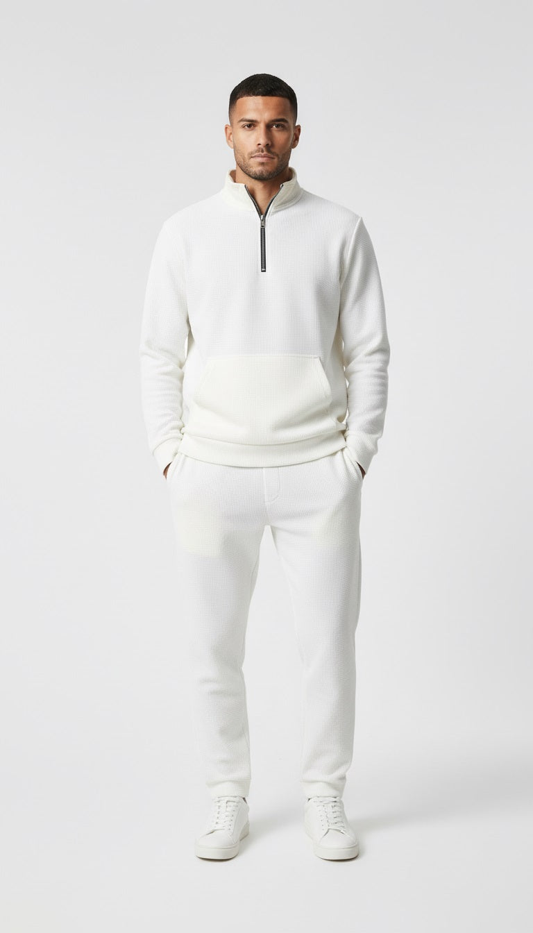 Man in a white tracksuit walking on a city street