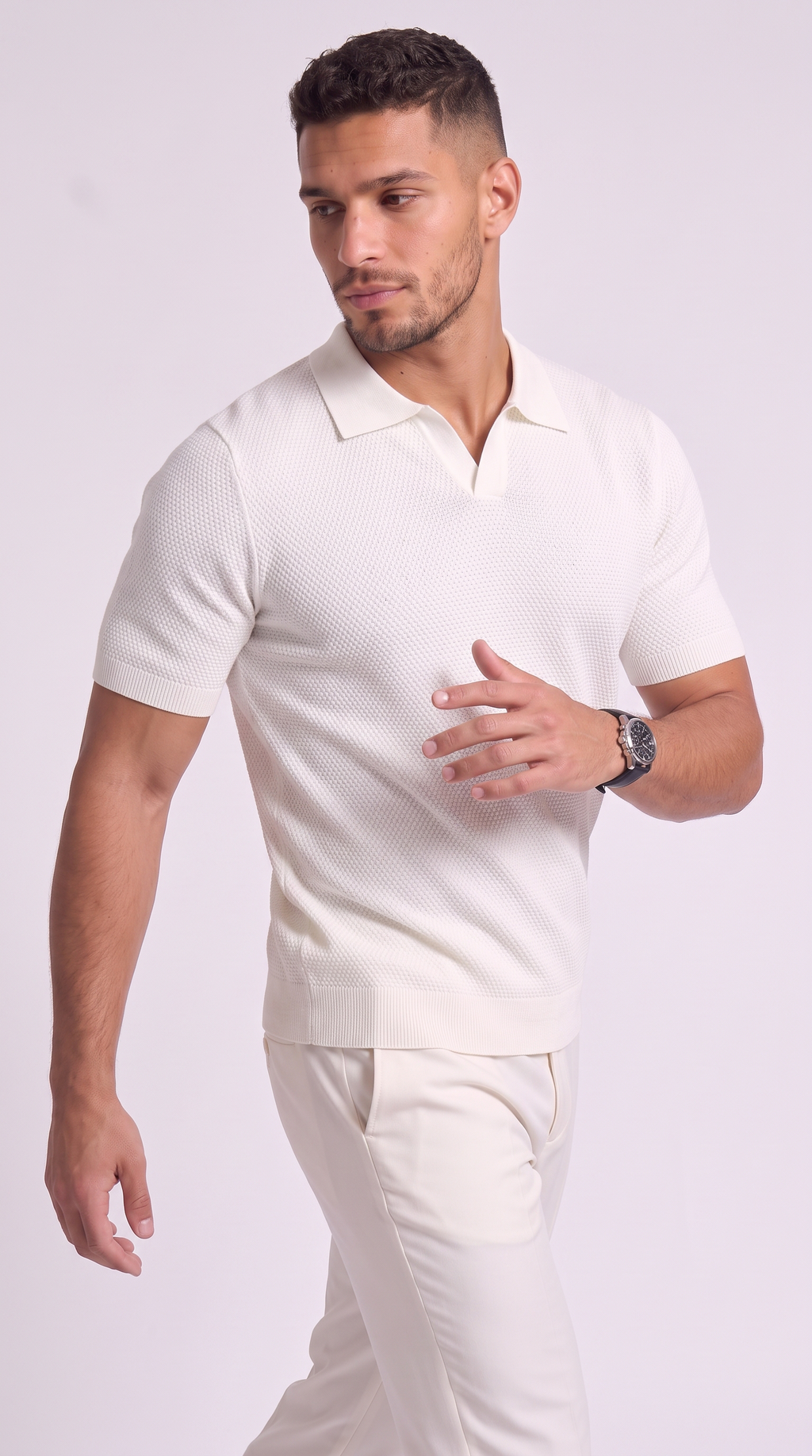 A man modeling a short-sleeve polo shirt and matching trousers in a solid off-white color, photographed against a light gray studio background, from Meleche Fashion USA or Meléche (short as (Mé))