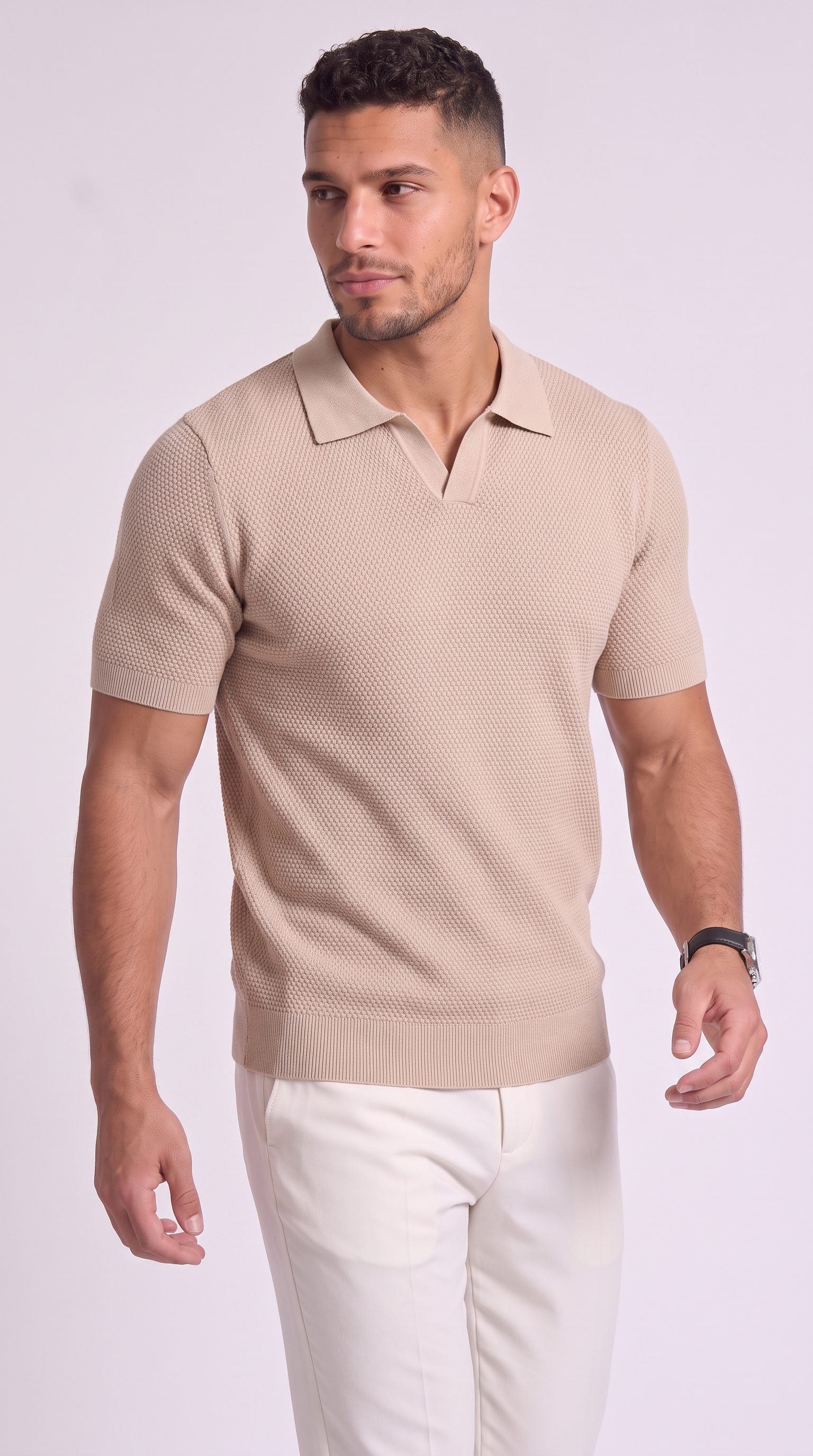 A man wearing a beige short-sleeve knit polo shirt and white trousers, standing against a light gray studio background, from Meleche Fashion USA or Meléche (short as (Mé))