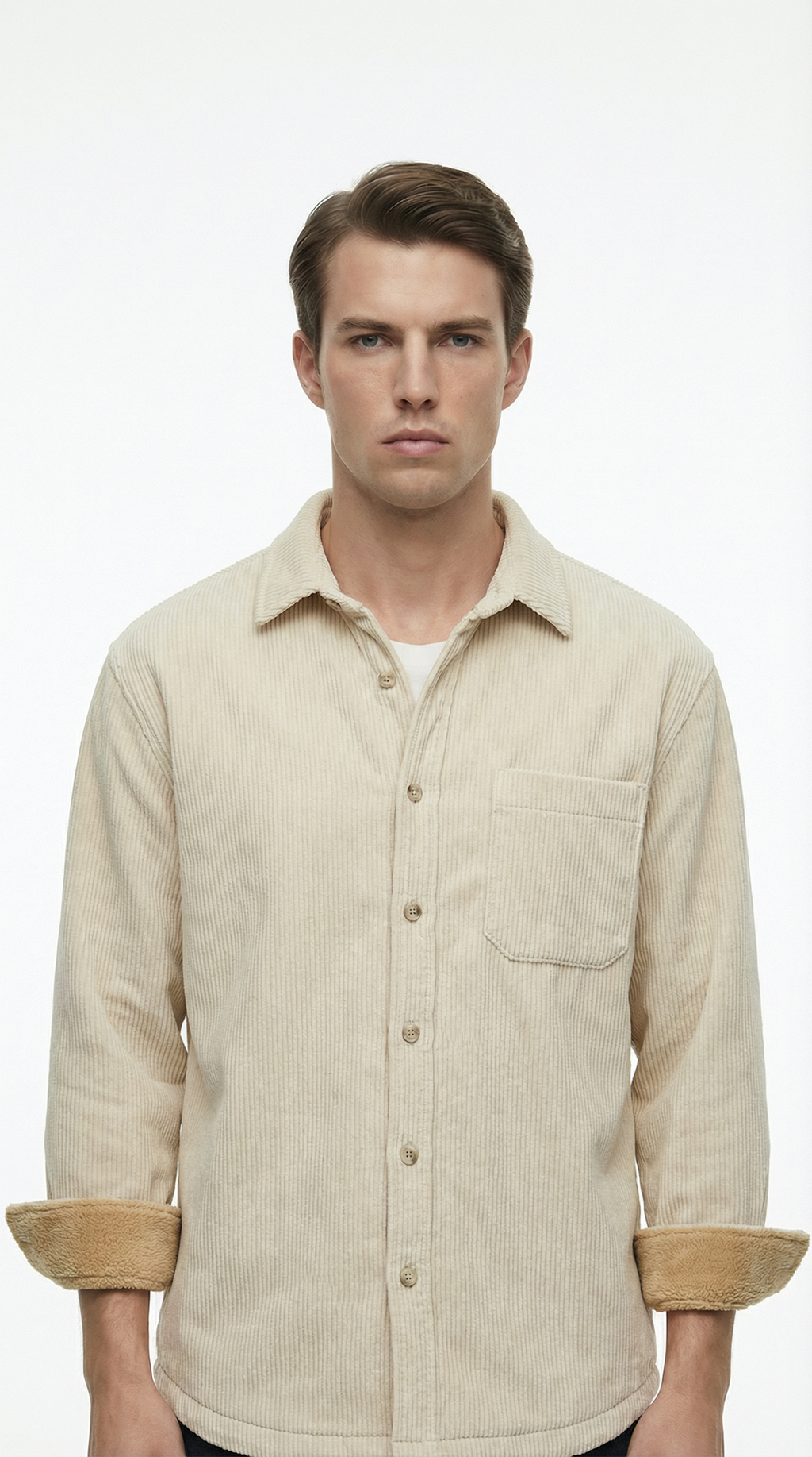 Man wearing a beige corduroy shirt with rolled-up sleeves on a white background