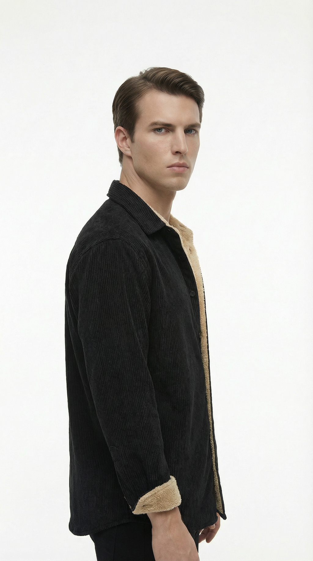 Man wearing a black jacket over a beige shirt on a white background