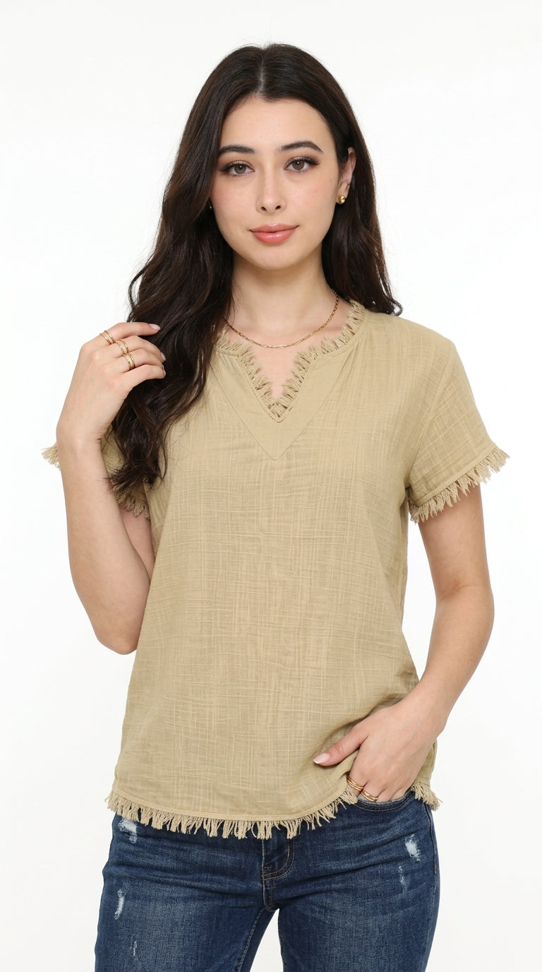A woman modeling a beige short-sleeve top with a V-neck and frayed fringe trim, paired with blue jeans, against a plain white background, from Meleche Fashion USA or Meléche (short as (Mé))