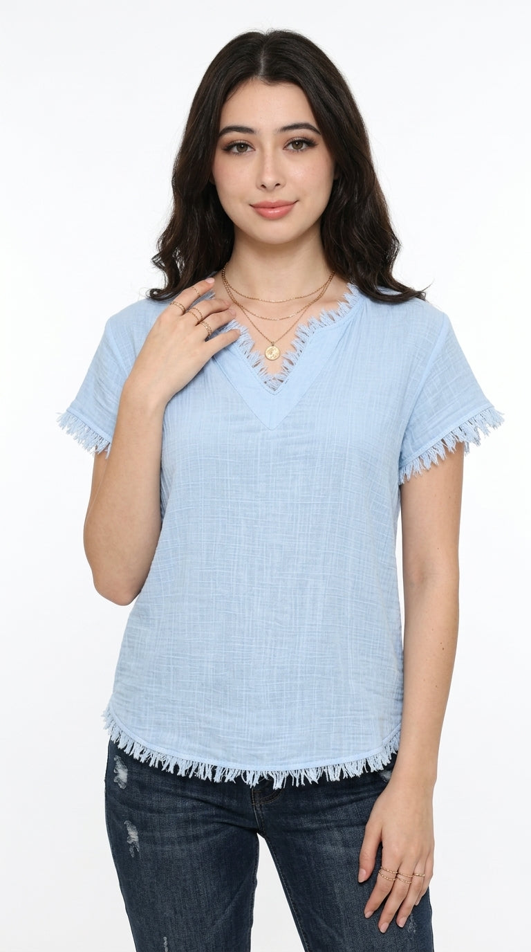 A woman modeling a light blue short-sleeve top with a frayed V-neck and frayed hem, paired with dark blue jeans, against a plain white background, from Meleche Fashion USA or Meléche (short as (Mé))