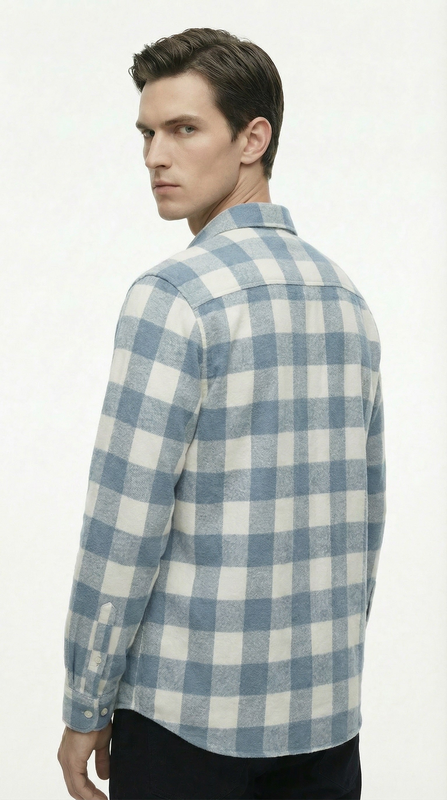 Blue and white checkered shirt on a wooden hanger against a gray background