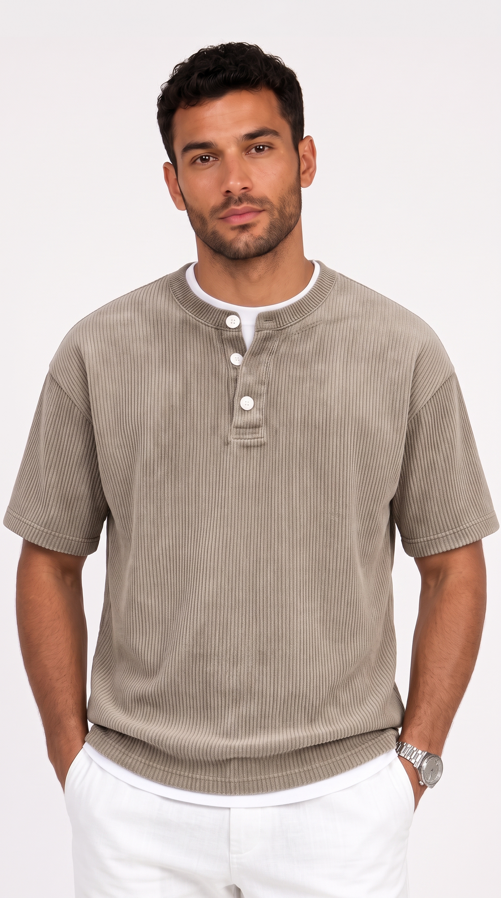 A man wearing a taupe ribbed short-sleeve henley shirt with white buttons and a white undershirt, paired with white pants, against a light gray studio background, from Meleche Fashion USA or Meléche (short as (Mé))