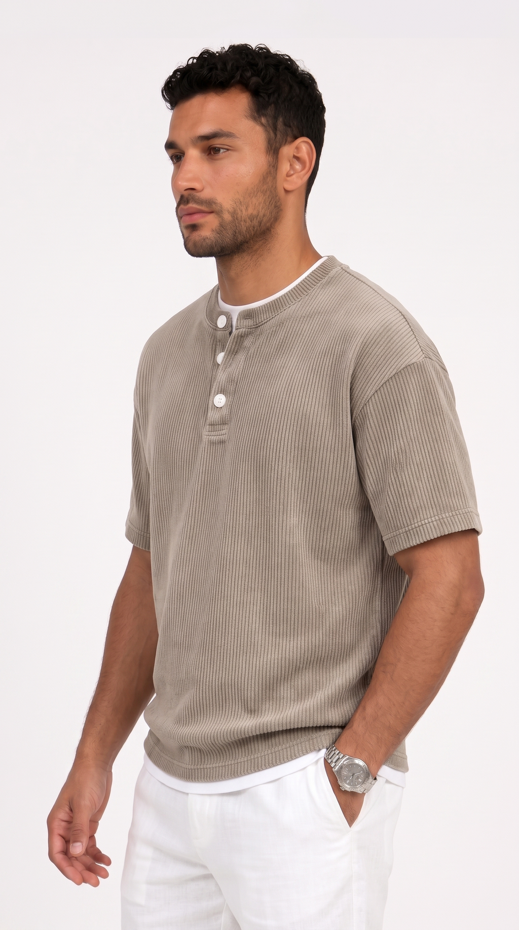 A man wearing a light taupe ribbed short-sleeve henley shirt with white pants, photographed against a clean white studio background, from Meleche Fashion USA or Meléche (short as (Mé))
