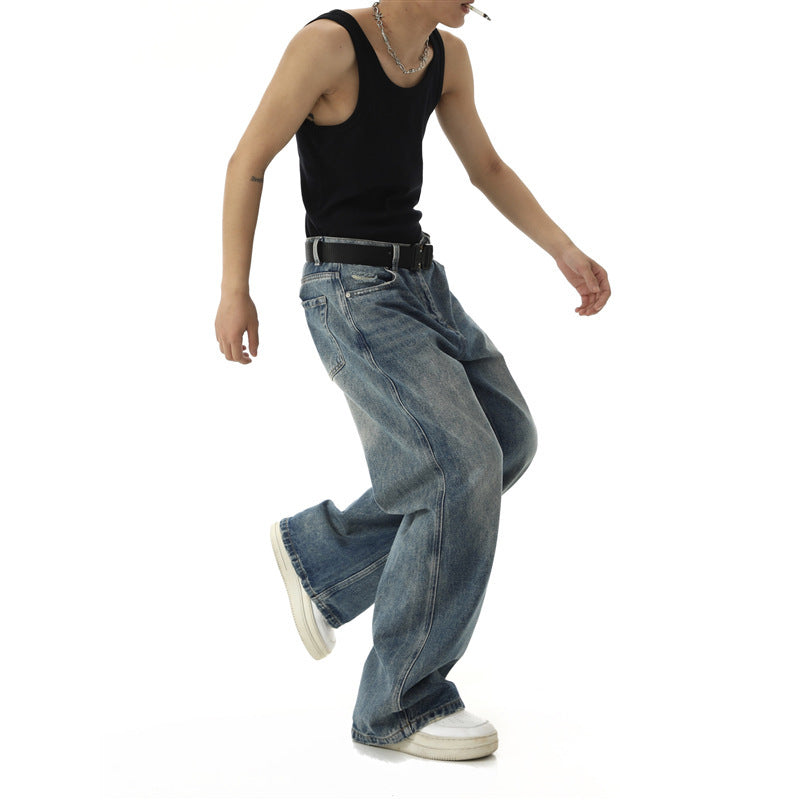Person wearing a black tank top and blue jeans on a white background