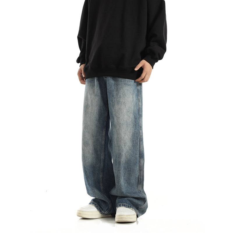 Person wearing a black hoodie and blue jeans on a white background