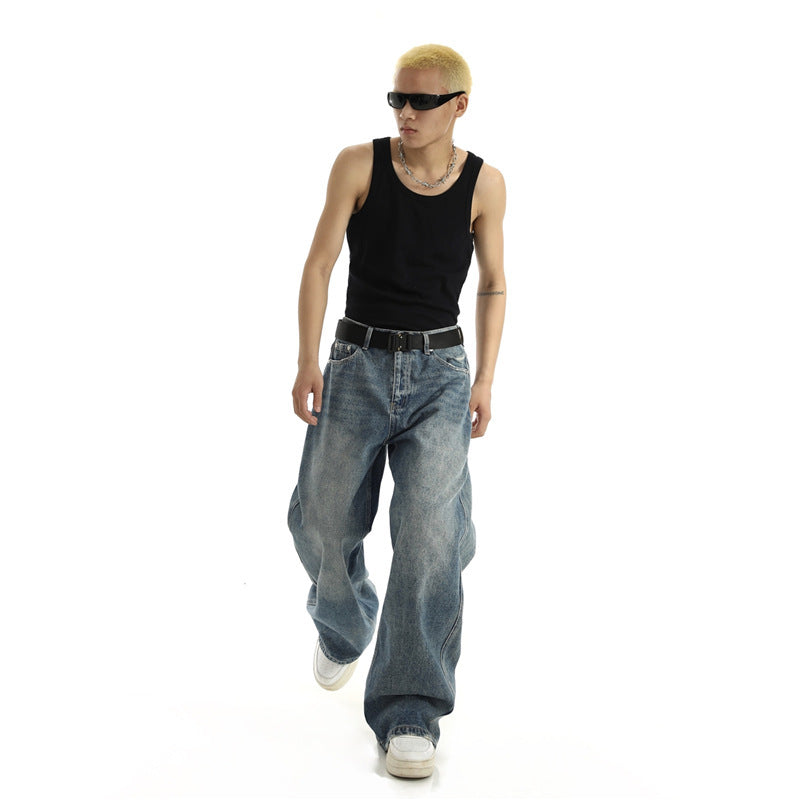 Person wearing a black tank top and blue jeans on a white background