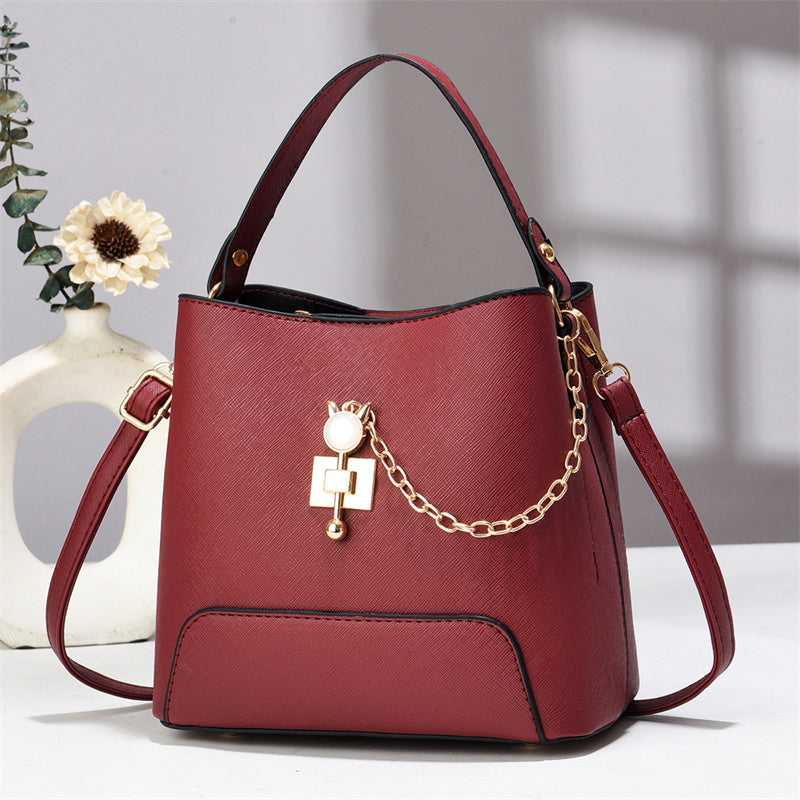 Xen - Red handbag with a gold chain detail on a light background