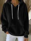 Black hoodie with white drawstrings worn by a person indoors.