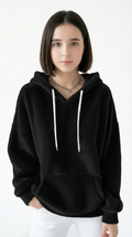 Woman wearing a black hoodie with white drawstrings on a white background
