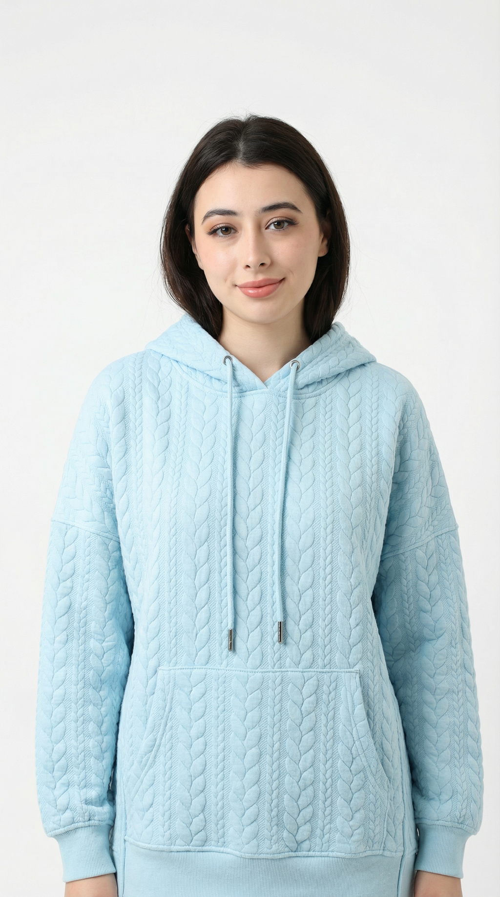 Woman wearing a light blue cable knit hoodie on a white background