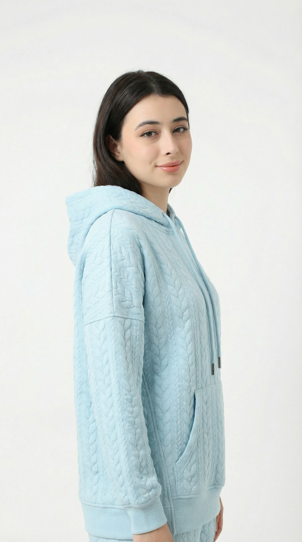 Woman wearing a light blue hoodie against a white background