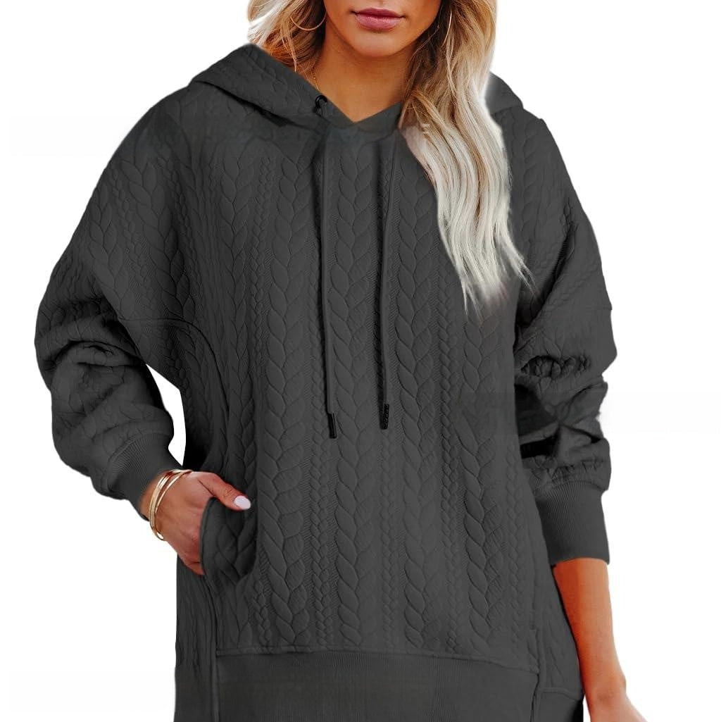 Dark gray quilted hoodie worn by a person on a white background